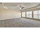 Large bedroom with tray ceiling, fan, and three windows providing ample natural light at 6793 Oconee Pl, Fairburn, GA 30213