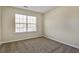 Empty bedroom with carpeted floors and a large window at 6793 Oconee Pl, Fairburn, GA 30213