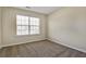 A simple bedroom with neutral carpeting and a large window at 6793 Oconee Pl, Fairburn, GA 30213