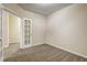Bedroom features neutral carpet and paint with a view of additional spaces via glass-paned doors at 6793 Oconee Pl, Fairburn, GA 30213
