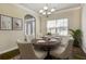 Dining room featuring a wooden table set for six, elegant decor, and plenty of natural light at 6793 Oconee Pl, Fairburn, GA 30213