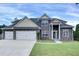 Charming two-story home with a stone facade, well-manicured lawn, and a three car garage at 6793 Oconee Pl, Fairburn, GA 30213