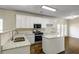 Clean kitchen with white cabinets, granite countertops, stainless steel appliances, and hardwood floors at 6793 Oconee Pl, Fairburn, GA 30213