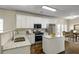 Modern kitchen with white cabinets, stainless steel appliances, granite countertops, and a dining area at 6793 Oconee Pl, Fairburn, GA 30213