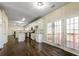 View of the kitchen, living room, and deck area with hardwood floors and lots of natural light at 6793 Oconee Pl, Fairburn, GA 30213