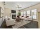 Comfortable living room with a fireplace, hardwood floors, neutral walls, and plenty of natural light at 6793 Oconee Pl, Fairburn, GA 30213