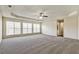 Spacious living room featuring neutral walls, plush carpet, tray ceiling and multiple windows for natural light at 6793 Oconee Pl, Fairburn, GA 30213