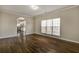A living room featuring hardwood floors, a large window, and an arched doorway at 6793 Oconee Pl, Fairburn, GA 30213