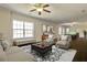 Beautifully furnished living room with neutral colors, ceiling fan, and large window with plenty of natural light at 6793 Oconee Pl, Fairburn, GA 30213