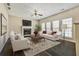Inviting living room with plush seating, fireplace, and a ceiling fan for added comfort at 6793 Oconee Pl, Fairburn, GA 30213