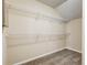Walk-in closet showing white shelving units with a neutral carpet at 6793 Oconee Pl, Fairburn, GA 30213