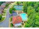 Aerial view of community amenities including a pool, tennis courts, and playground surrounded by lush greenery at 8070 Georgetown Cir, Suwanee, GA 30024