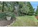 Well-manicured backyard featuring stone accents, mature trees, lush greenery, and an inviting outdoor space at 8070 Georgetown Cir, Suwanee, GA 30024