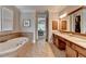 A luxurious bathroom with a soaking tub, double vanity, and access to a walk-in closet at 8070 Georgetown Cir, Suwanee, GA 30024