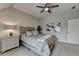 Bright bedroom with a ceiling fan, a tufted headboard bed, a nightstand, and neutral-colored walls at 8070 Georgetown Cir, Suwanee, GA 30024