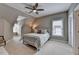 Cozy bedroom featuring a neutral color scheme, a ceiling fan, windows and a comfortable queen bed at 8070 Georgetown Cir, Suwanee, GA 30024