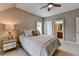 Cozy bedroom with neutral tones, a ceiling fan, a queen-sized bed, and an ensuite bathroom at 8070 Georgetown Cir, Suwanee, GA 30024