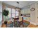 Bright breakfast nook with a modern light fixture, granite table, and built-in cabinets and countertop at 8070 Georgetown Cir, Suwanee, GA 30024