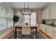 Bright breakfast nook with modern chandelier, granite table, and built-in cabinets for functional elegance at 8070 Georgetown Cir, Suwanee, GA 30024