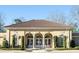 Exterior of clubhouse with beautiful French doors, beige brick and a brown tile roof at 8070 Georgetown Cir, Suwanee, GA 30024
