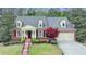 Charming brick home featuring manicured landscaping, dormer windows and a two-car garage at 8070 Georgetown Cir, Suwanee, GA 30024