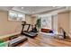 Home gym with workout equipment including treadmill, bike, weights and yoga mat next to windows at 8070 Georgetown Cir, Suwanee, GA 30024