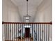 Foyer hallway with a decorative chandelier, wood flooring and metal railing with front door view at 8070 Georgetown Cir, Suwanee, GA 30024