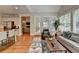 Bright living room featuring hardwood floors, large windows, and an open concept design to the kitchen at 8070 Georgetown Cir, Suwanee, GA 30024