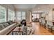 A naturally lit living room with hardwood floors, a comfortable gray sofa, and a view into the breakfast nook at 8070 Georgetown Cir, Suwanee, GA 30024