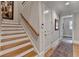 Elegant staircase with wooden handrail and steps complemented by neutral walls and a patterned rug at 8070 Georgetown Cir, Suwanee, GA 30024