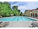 Large community swimming pool with lounge chairs and a beautiful building nearby at 8070 Georgetown Cir, Suwanee, GA 30024
