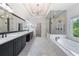 Luxurious bathroom featuring a double vanity, and a glass-enclosed shower and tub at 5395 Lacosta Ln, Alpharetta, GA 30022