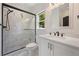 Modern bathroom with a marble shower, sleek black hardware and white vanity at 5395 Lacosta Ln, Alpharetta, GA 30022