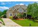 Stunning two-story home with a combination stone and brick facade, lush landscaping, and a long driveway at 5395 Lacosta Ln, Alpharetta, GA 30022