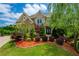 Elegant home exterior with manicured lawn, colorful foliage and stone accents at 5395 Lacosta Ln, Alpharetta, GA 30022