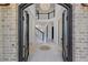 Grand foyer featuring a soaring ceiling, elegant chandelier, white marble flooring, and an arched iron doorway at 5395 Lacosta Ln, Alpharetta, GA 30022