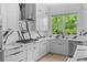 Gourmet kitchen with stainless steel appliances, waterfall island, and white custom cabinetry at 5395 Lacosta Ln, Alpharetta, GA 30022
