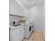 Bright laundry room with a sink, cabinets, and modern washer and dryer at 5395 Lacosta Ln, Alpharetta, GA 30022