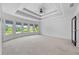 Large bedroom featuring tray ceilings, recessed lighting, and windows with views at 5395 Lacosta Ln, Alpharetta, GA 30022