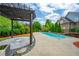 Beautiful pool with a pergola and manicured landscaping in the backyard at 5395 Lacosta Ln, Alpharetta, GA 30022