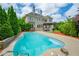 Backyard swimming pool with lush landscaping and an elegant brick home at 5395 Lacosta Ln, Alpharetta, GA 30022