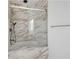 Elegant bathroom featuring marble tiling, a glass shower door, and a hand held shower at 5395 Lacosta Ln, Alpharetta, GA 30022