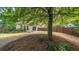 A view of the fenced backyard featuring a large tree for shade and lush greenery at 5510 Weddington Dr, Cumming, GA 30040