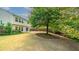 A view of the expansive backyard, featuring a mature tree and a patio area at 5510 Weddington Dr, Cumming, GA 30040