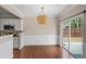Dining area with a sliding door to the backyard, wainscoting details, and modern light fixtures at 5510 Weddington Dr, Cumming, GA 30040