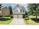 A well-manicured yard leads up to the two-story home with a two-car garage at 5510 Weddington Dr, Cumming, GA 30040