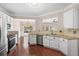 Open kitchen with stainless steel appliances, granite counters, white cabinets, and a view into the dining area at 5510 Weddington Dr, Cumming, GA 30040