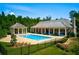 Luxurious community pool area with a covered patio, lush landscaping, and ample space for relaxation and entertainment at 4435 Pebble Rock Dr, Cumming, GA 30041