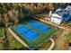 Aerial view of community tennis courts surrounded by lush landscaping and homes at 4435 Pebble Rock Dr, Cumming, GA 30041