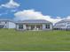 The back exterior of the home shows a large lawn and covered patio, great for relaxing and enjoying the outdoors at 449 Carmichael Cir, Canton, GA 30115
